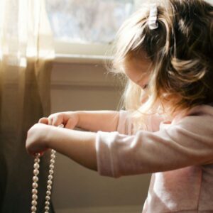 パールのネックレスを持つ幼女